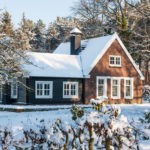 A cozy residential house surrounded by snow-covered trees in Omaha, NE, representing the need for year-round pest protection during Nebraska winters.