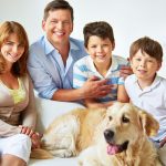 A happy family with their Golden Retriever in a clean home, representing pet-safe residential pest control in La Vista, NE.