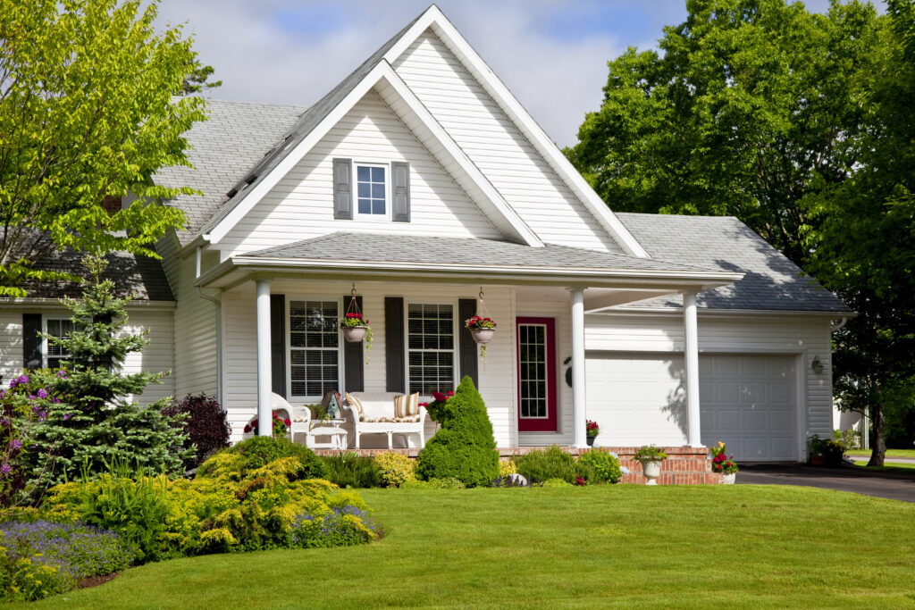 Exterior of a white residential home in Omaha, NE, featuring a well-maintained lawn and professional landscaping.