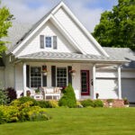 Exterior of a white residential home in Omaha, NE, featuring a well-maintained lawn and professional landscaping.
